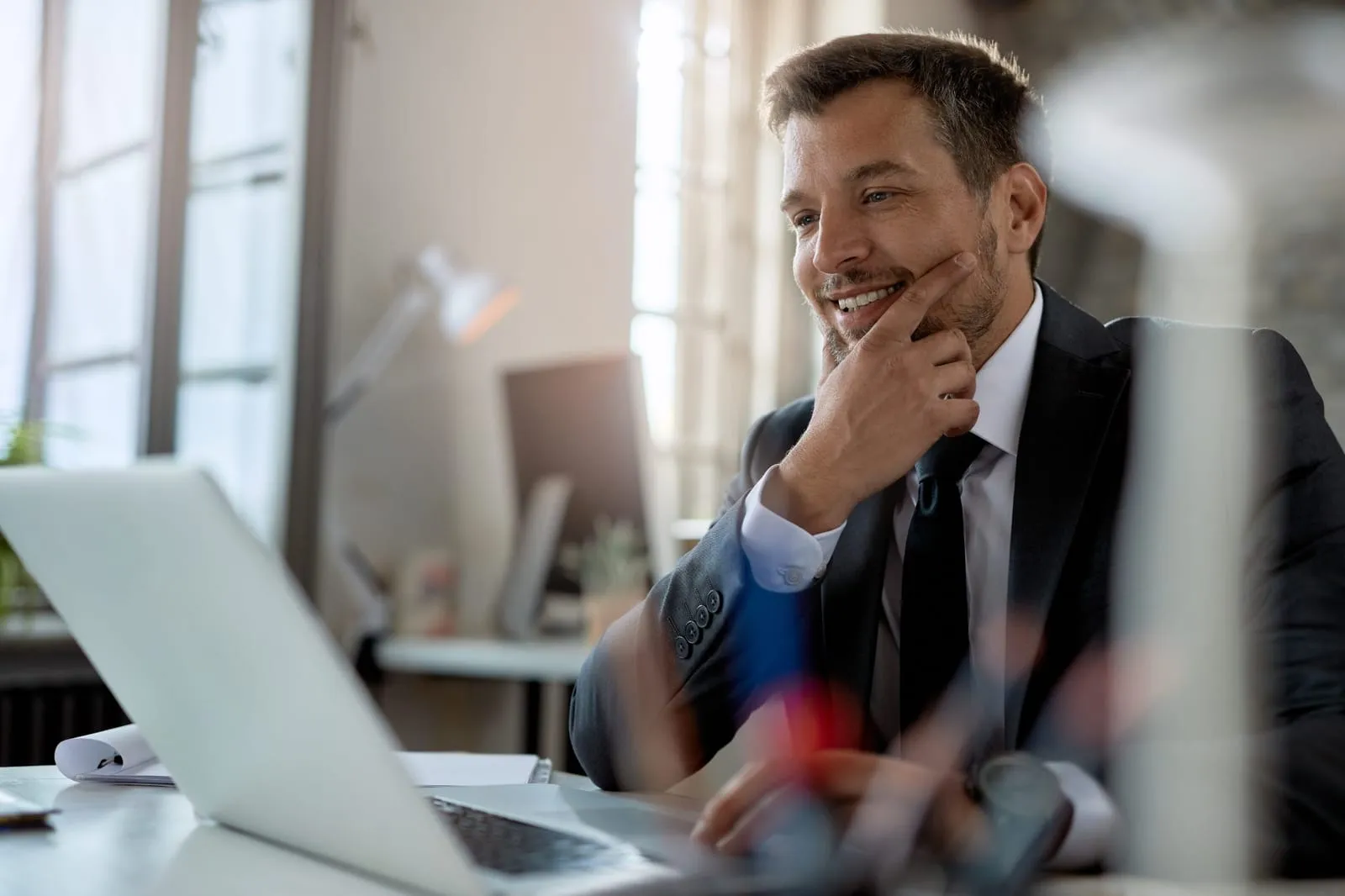 Manager sorridente davanti al laptop segue l’andamento di una sfida su LearningBOX Contest